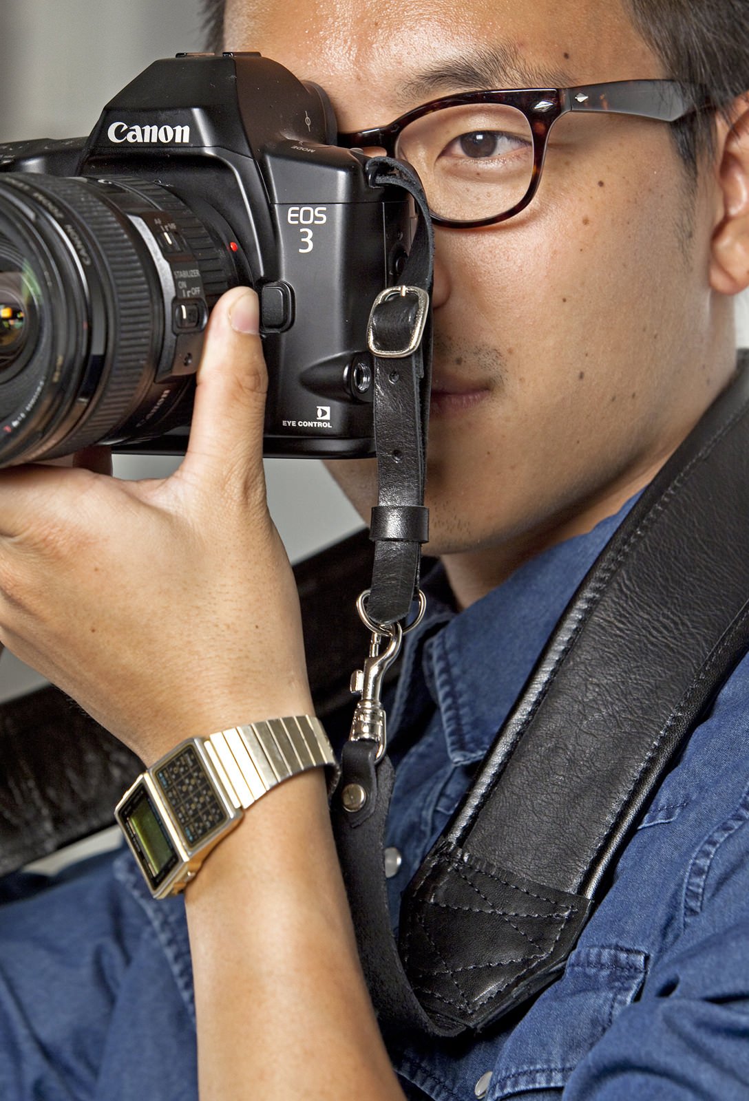 Man taking photo with camera strap image 