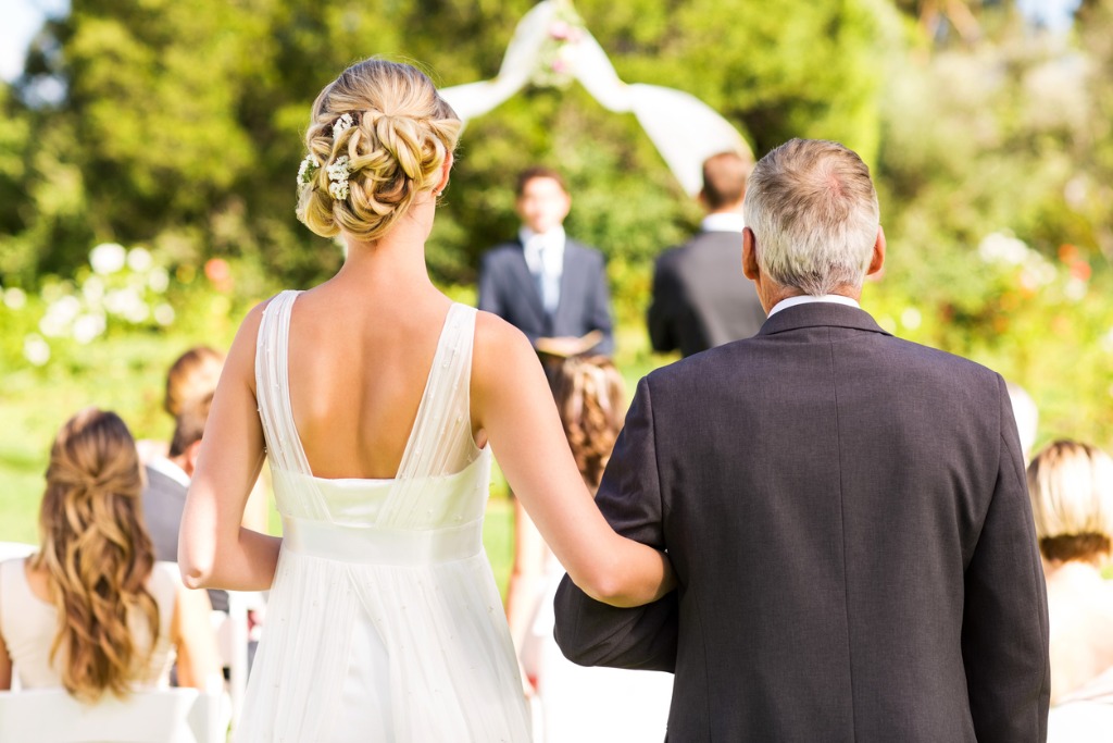 bride and father walking down the aisle during outdoor wedding picture id187184068