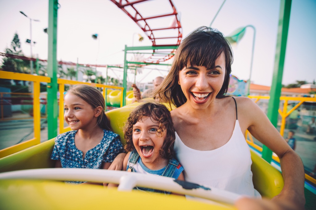 little son and daughter with mother on roller coaster ride picture id865026638 image 