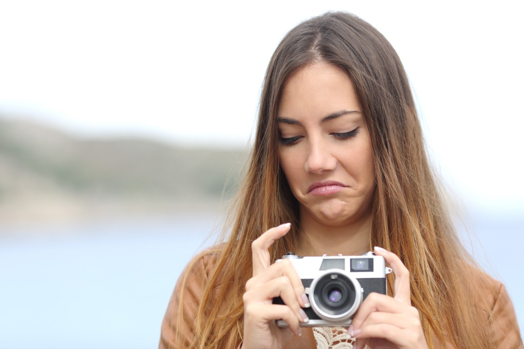 upset woman looking her old slr photo camera picture id492810294 image 