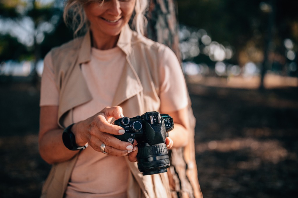senior woman using camera and looking at photos in nature picture id979294778 image 