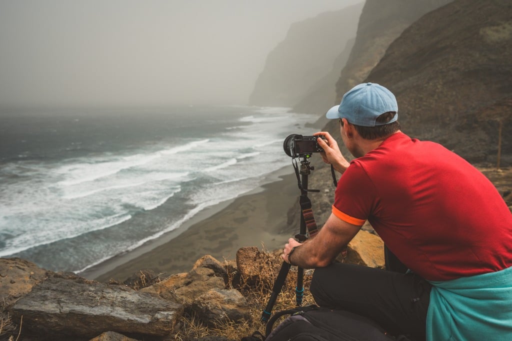 tourist making photograph of cliff coastline with ocean waves from picture id956667234
