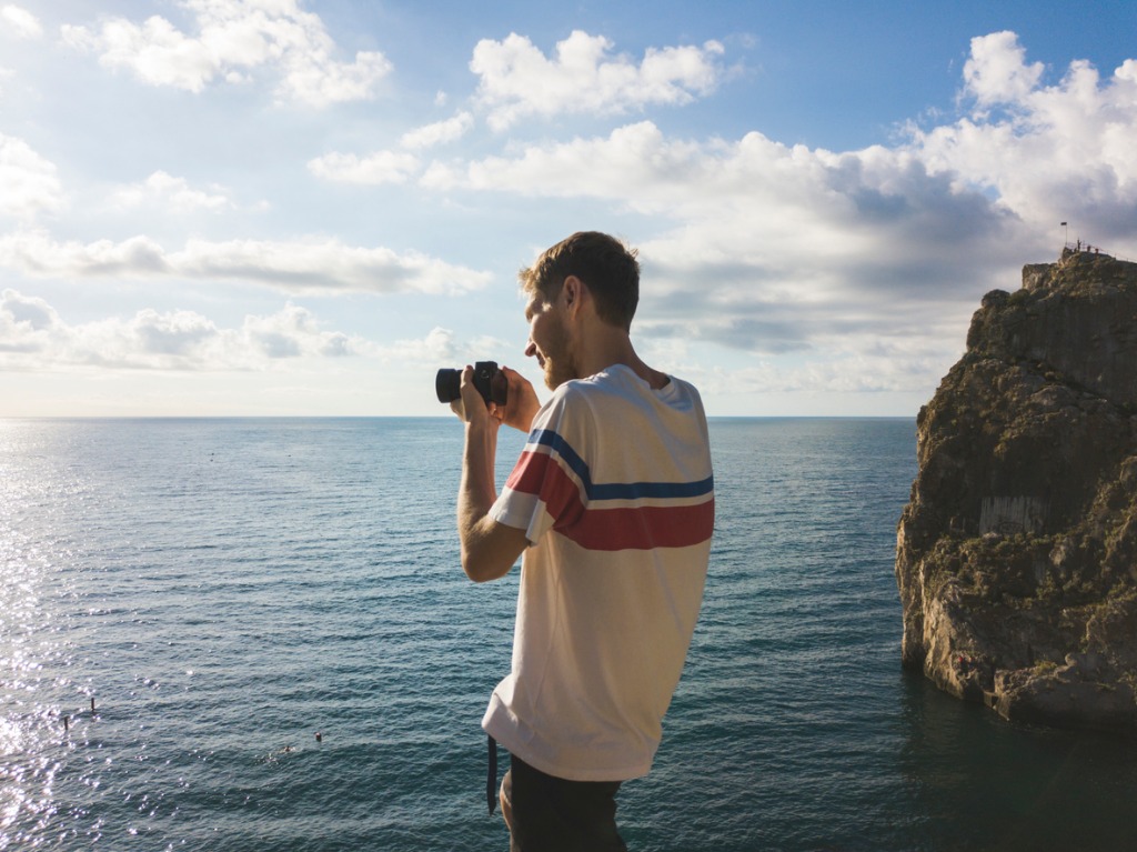 man with sea and sky on background taking photography with mirrorless picture id1002427498 image 