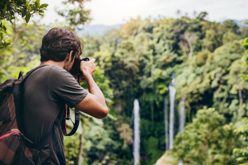 male hiker photographing a waterfall in forest picture id580120812 image 