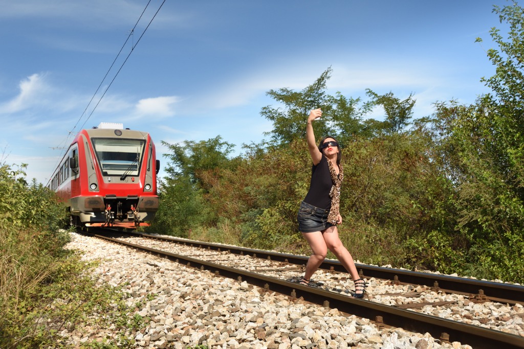 woman taking dangerous selfie on railway track picture id854355004 image 